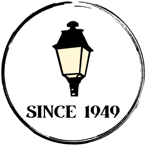 A circular logo with a black border featuring a vintage-style streetlamp in the center. Below the lamp, bold black text reads “SINCE 1949.”